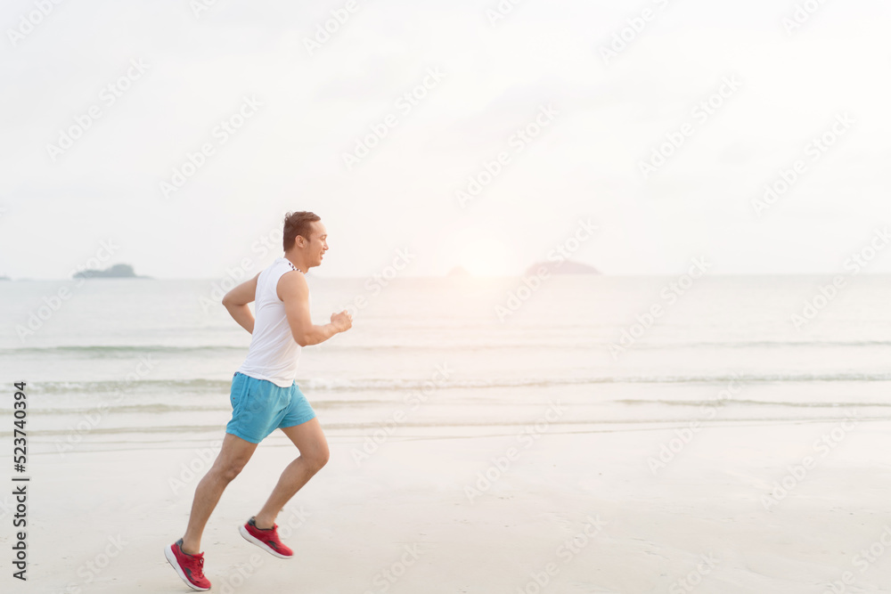 asian sport man running along seaside. running on beach with healthy toned legs body, Hamstring muscles, knee joint health active lifestyle panoramic banner background. the beach runners working out