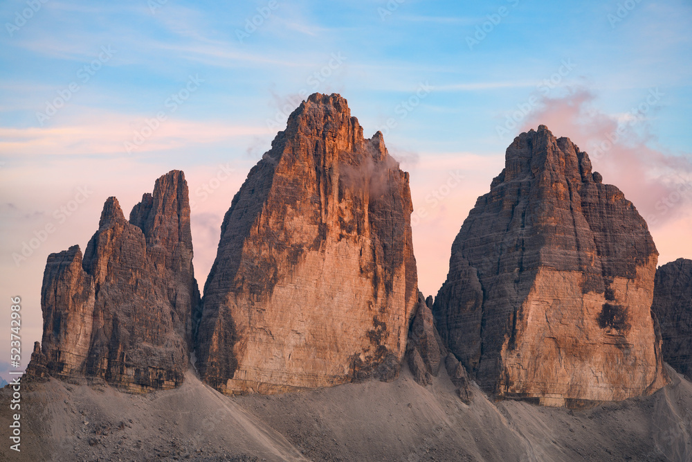 Stunning view of the Three Peaks of Lavaredo (Tre cime di Lavaredo) during a beautiful sunset. The Three Peaks of Lavaredo are the undisputed symbol of the Dolomites, Italy..