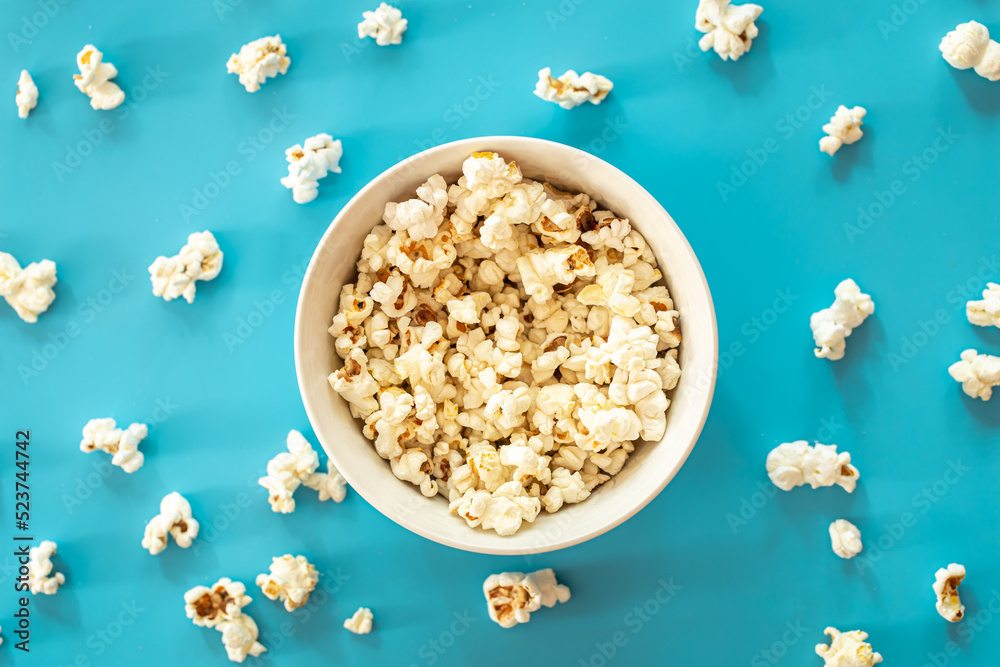 Plate with popcorn on a blue background, flat lay. Plate with popcorn on a blue background, flat lay.
