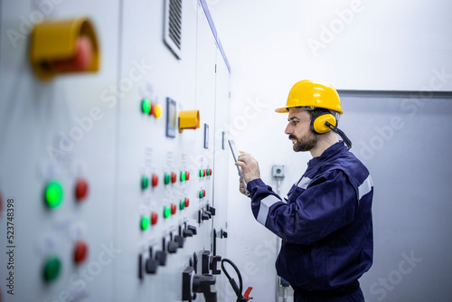 Industrial electric engineer checking installations and voltage.