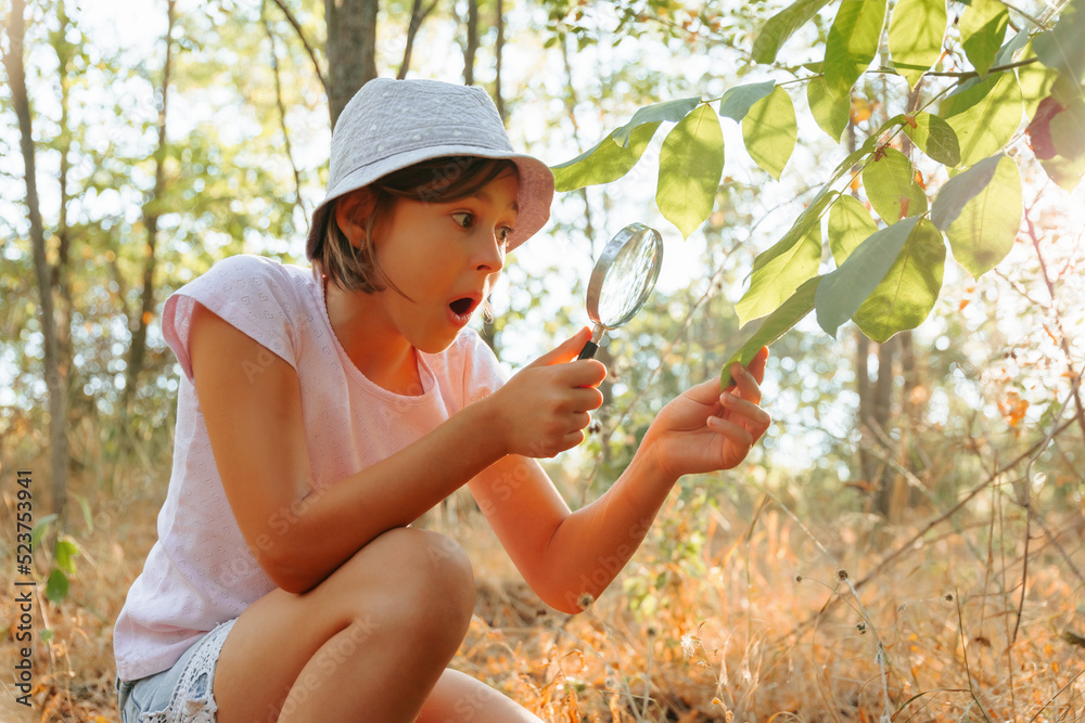 shocked kid girl exploring nature outside with magnifying glasses and ...
