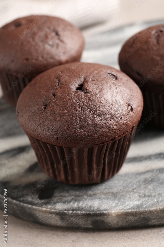 Delicious fresh chocolate cupcakes on grey marble board, closeup Delicious fresh chocolate cupcakes on grey marble board, closeup