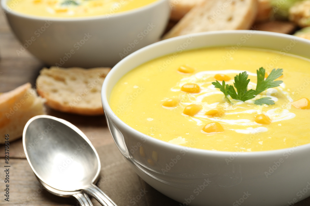 Delicious creamy corn soup served on table, closeup