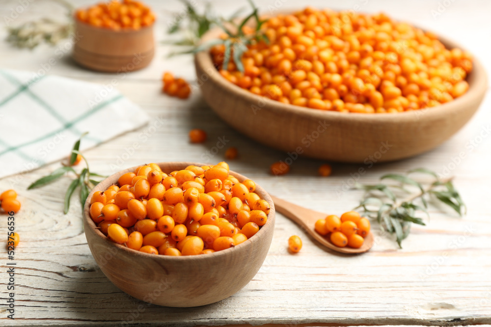 Fresh ripe sea buckthorn on white wooden table Fresh ripe sea buckthorn on white wooden table