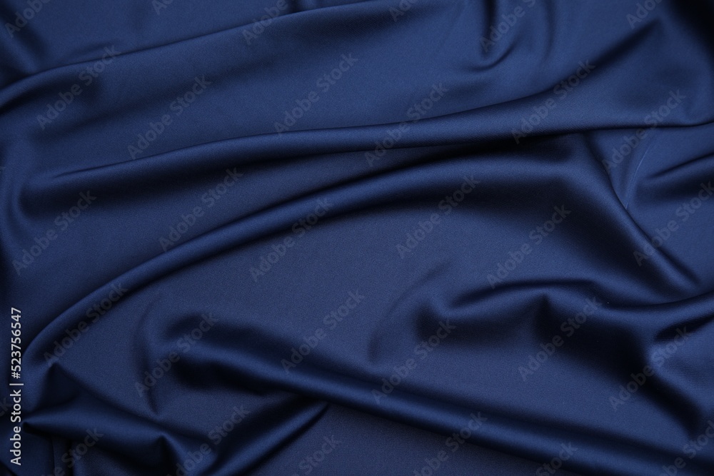 Fototapeta premium Crumpled dark blue silk fabric as background, top view