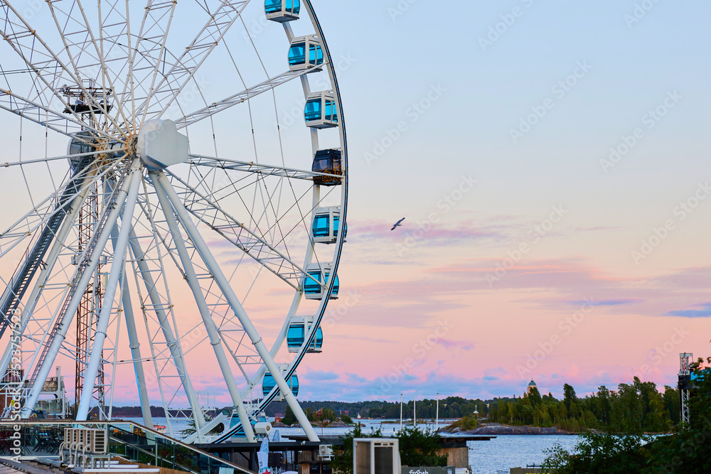 helsinki ferrish wheel for tourism and amusement in finland during summer evening sunset with a seaqull