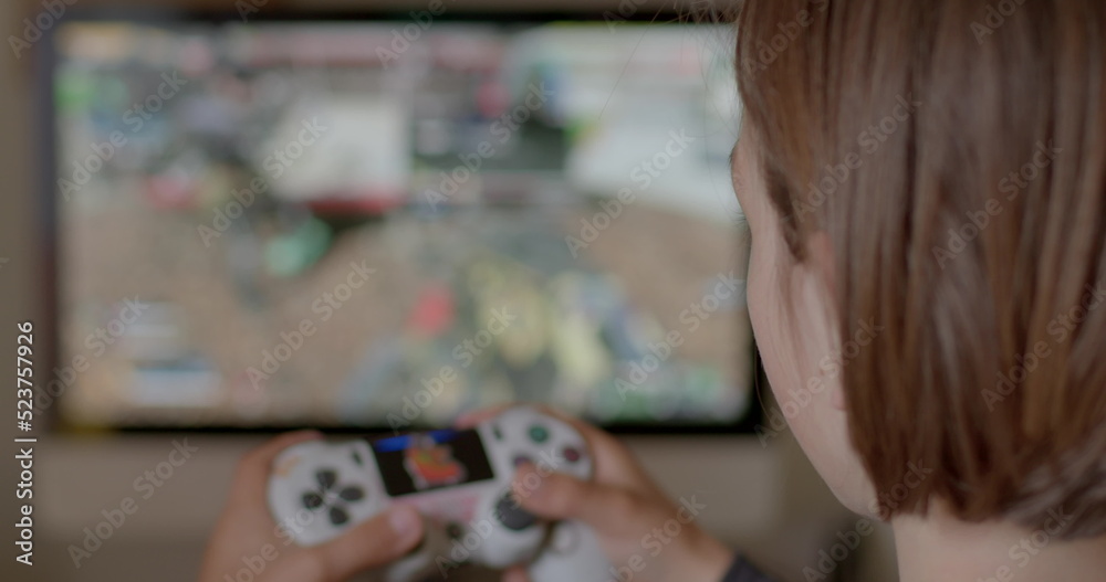 Fototapeta premium Child plays video games after school, kid spends too much time playing games. Action game can boost cognitive abilities perception, attention, and reaction time. 
