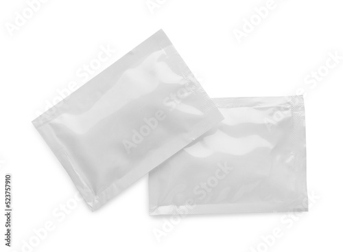 Blank sachets with wet wipes on white background, top view. Space for design