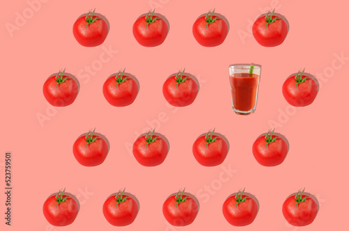 Pattern. Red tomatoes and one glass of tomato juice on a pink background. Concept of healthy eating. Horizontal orientation.