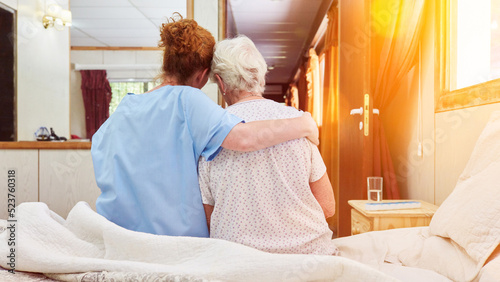 Fotografia Nurse in hospice hugs elderly woman for comfort