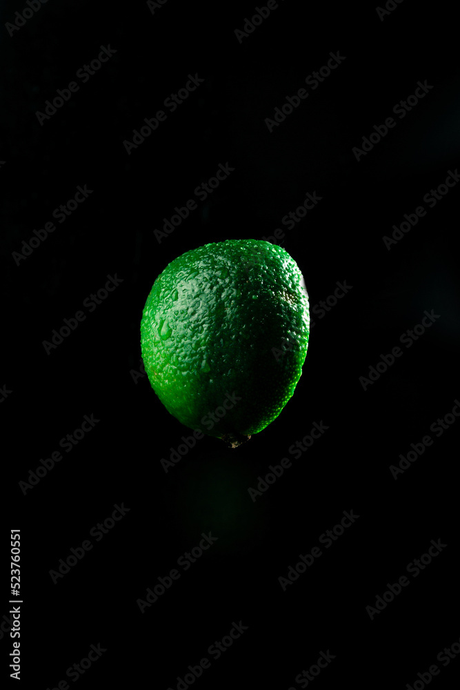 Slice of juicy and fresh lime isolated on black background. close up Slice of juicy and fresh lime isolated on black background. close up