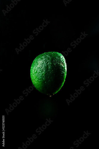 Slice of juicy and fresh lime isolated on black background. close up © Levynets3008