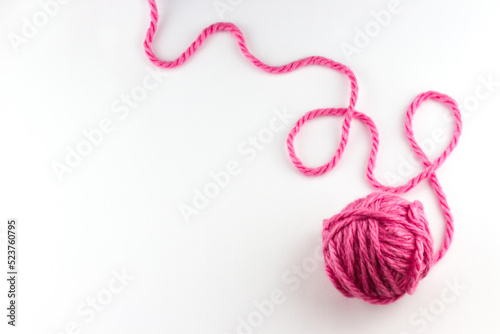 Top view of pink yarn ball with woolen thread on white background  photo