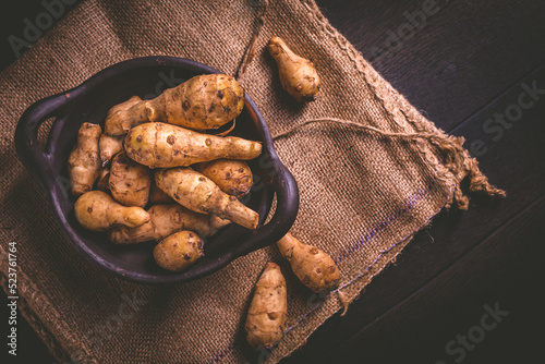 Bild auf Leinwand Raw jerusalem artichoke. Topinambur,  vegetable root in bowl