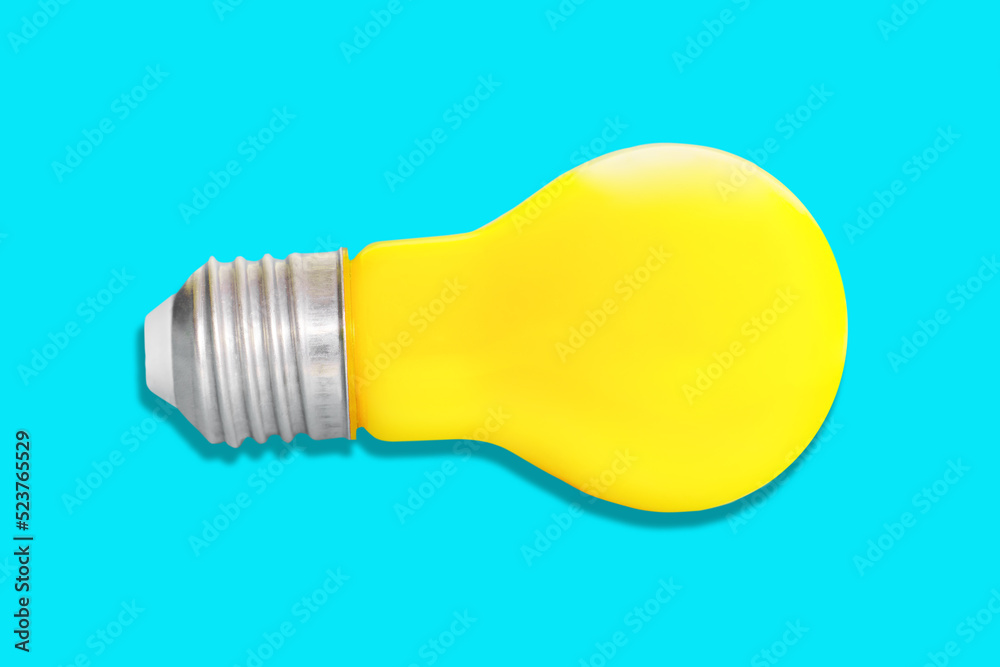 Yellow light bulb isolated on blue background Yellow light bulb isolated on blue background
