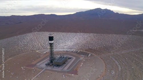 Aerial Backward Shot Of Tower Amidst Solar Energy Panels In Desert By Clark Mountain - Nipton, California photo