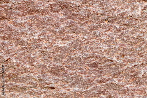 Texture of a stone wall with cracks and scratches which can be used as a backgr. Texture of red stone. © homeworlds