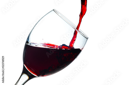 Pouring red wine into a glass isolated on white background