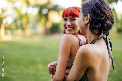 Cute red hair girl looking at her girlfriend, lgbt couple spending day outdoor.