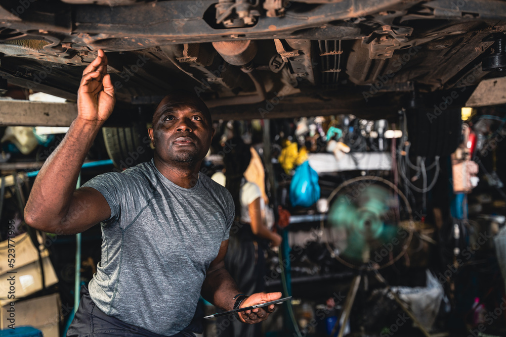 Car suspension specialists are carefully examining the broken car. Car suspension specialists are carefully examining the broken car.