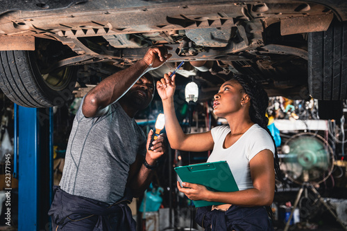 Two mechanic was checking the car suspension.