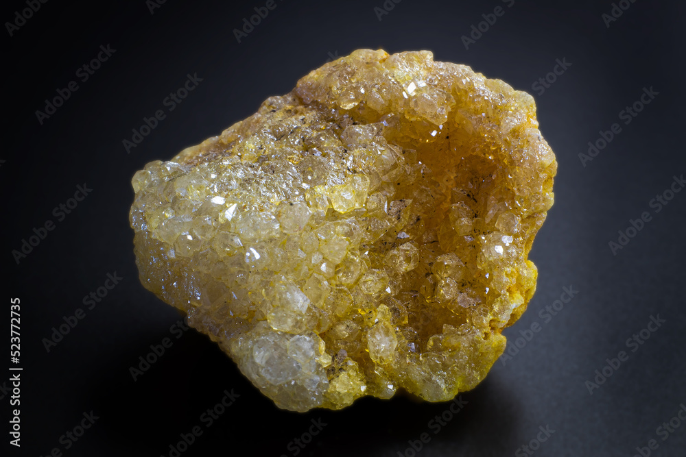 Macro of a yellow sparkly druzy agate geode isolated on black surface Macro of a yellow sparkly druzy agate geode isolated on black surface