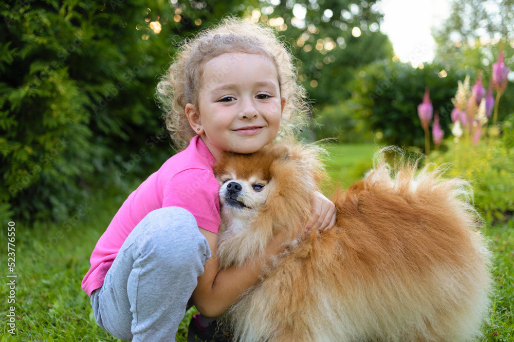 Portrait little girl owner holding and hugging Pomeranian. best friends