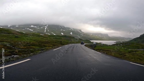 First person view of a road through norwegian mountains, gloomy, foggy, Norway