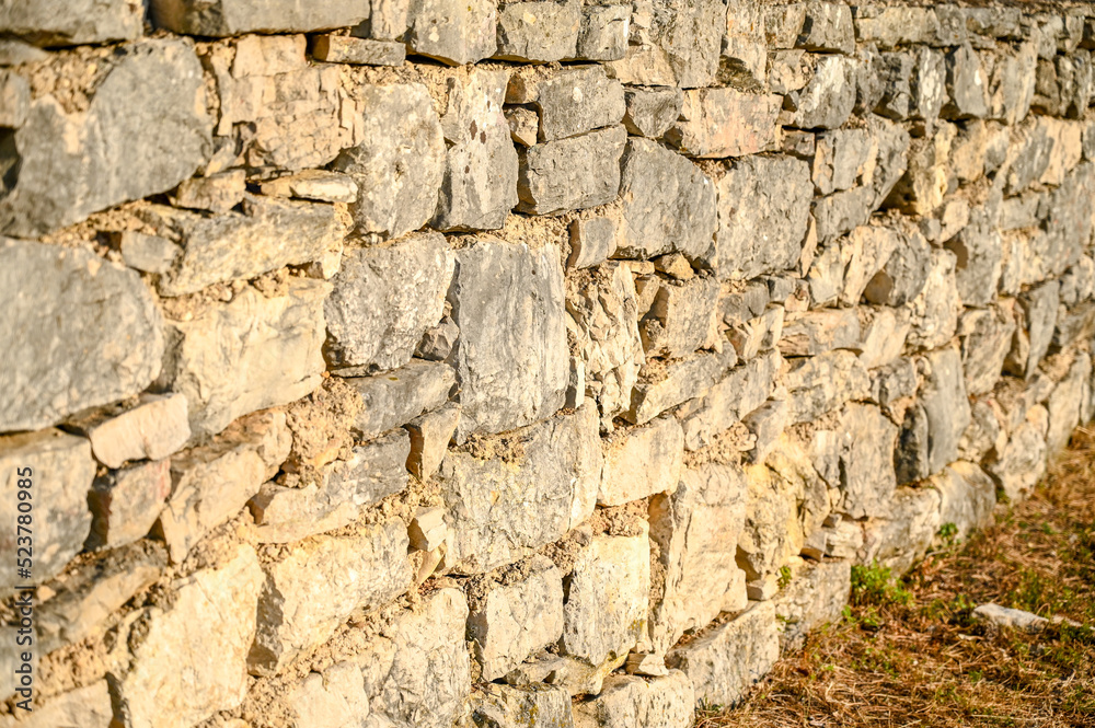 Stone wall in the field, close up. Medieval stone wall pattern.  
