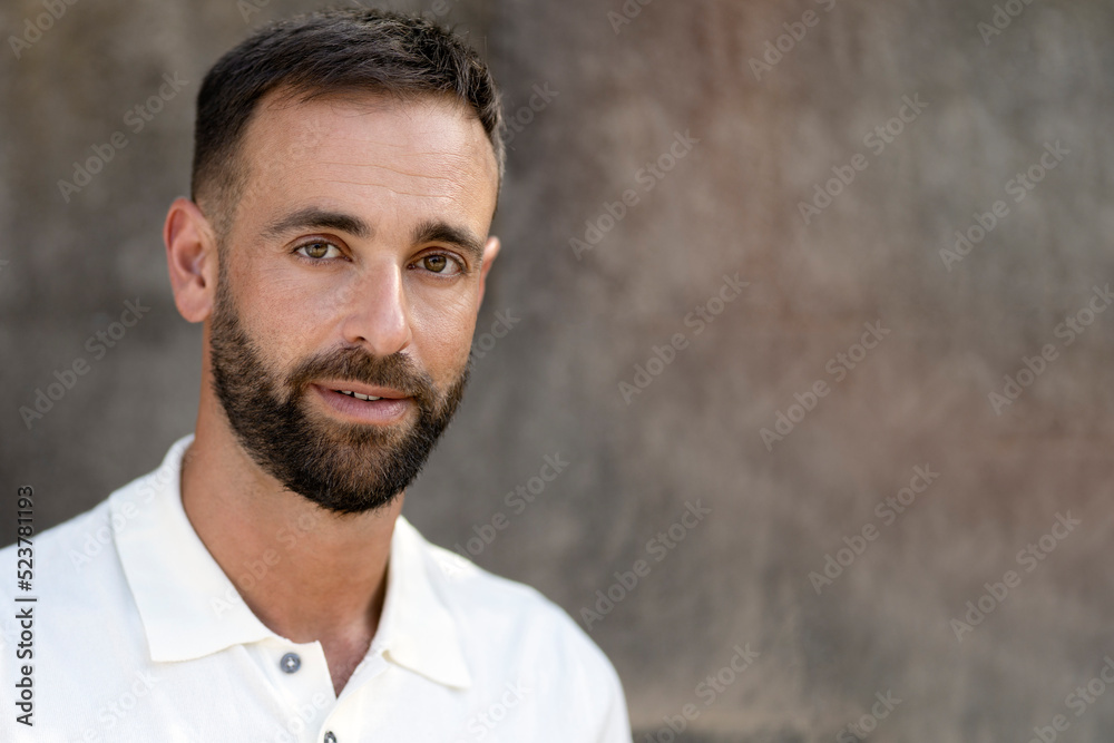 Handsome bearded man with stylish hair  looking at camera isolated on grey background, copy space 