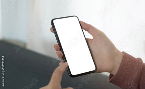Mockup image blank white screen cell phone.women hand holding texting using mobile on sofa © wichayada