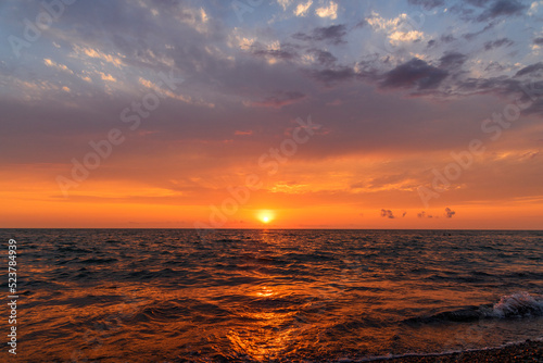 Beautiful sunset over the sea with bright orange clouds.