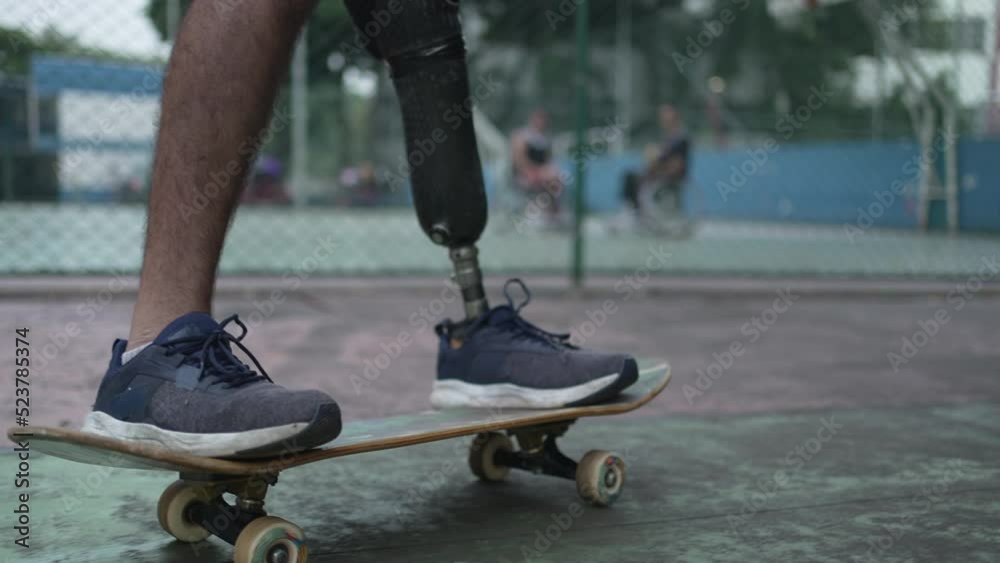 Disabled person riding skateboard with prosthetic leg. Athletic