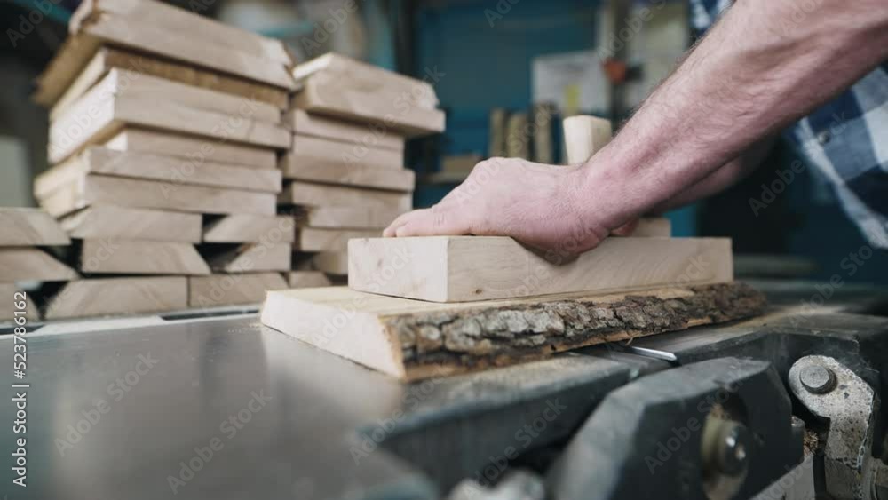Close-up of hands and wood workpiece on planer. An unrecognizable man works as a carpenter. Close-up of hands and wood workpiece on planer. An unrecognizable man works as a carpenter.