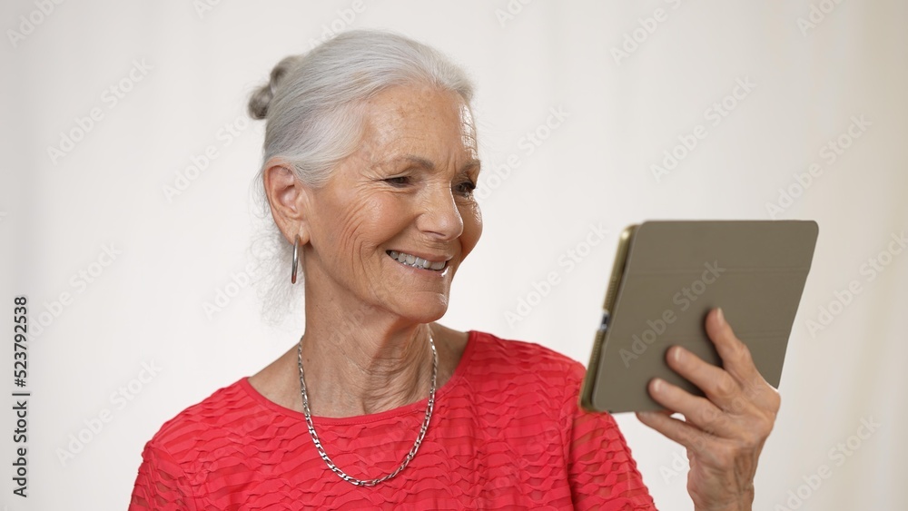 Portrait of smiling mature elderly woman posing holding phone video chat isolated on solid white background. Portrait of smiling mature elderly woman posing holding phone video chat isolated on solid white background.