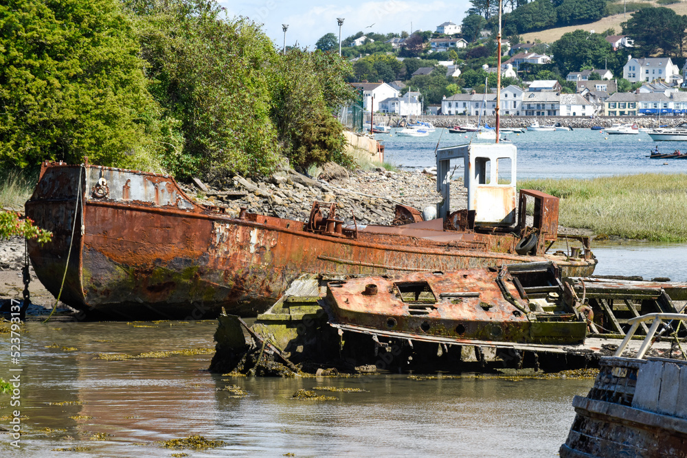 An old rusty fishing boat is sinking at low tide