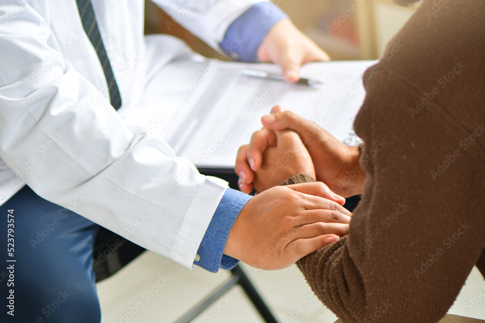 Close-up of female doctor in white coat holding senior patient's hand and supporting him Close-up of female doctor in white coat holding senior patient's hand and supporting him