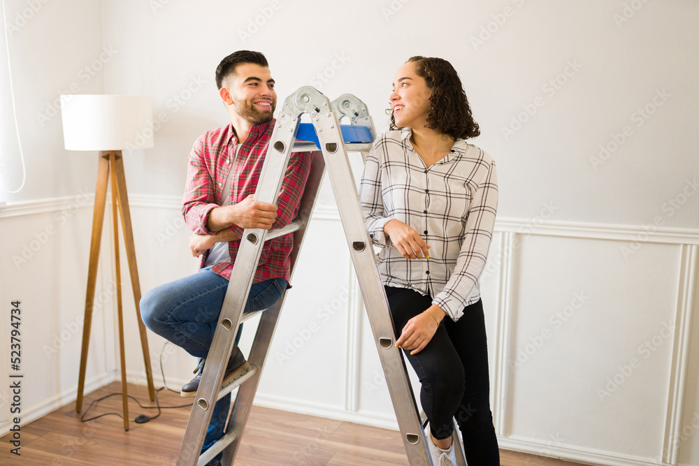 Excited couple having fun while doing home improvements around the house