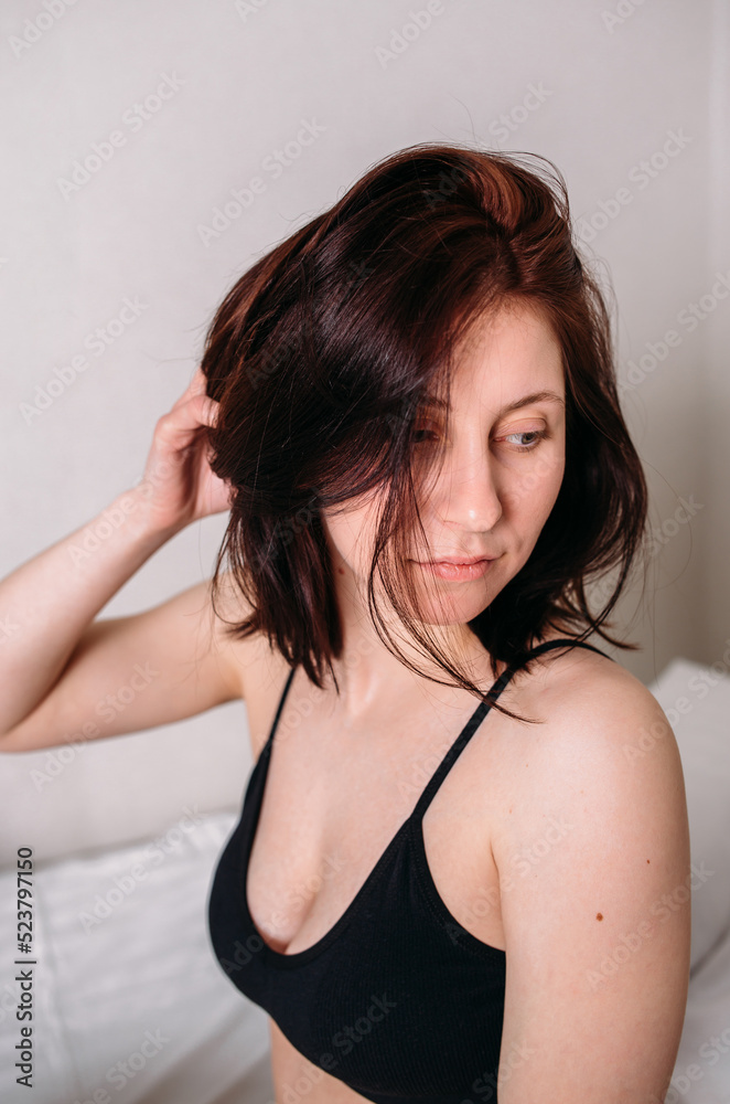 Portrait of a young beautiful brunette lying in bed wearing underwear Portrait of a young beautiful brunette lying in bed wearing underwear