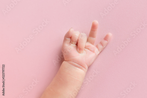 hands of a newborn baby. small children's hand on a pink background