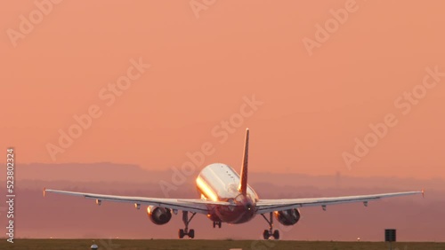Cinematic footage of a jet plane taking off and climbing into the sunset. Picturesque sunset and flying away airliner. Tourism and travel concept, modern aviation photo
