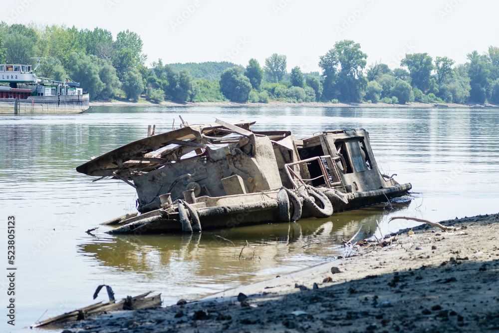 View of the Danube River. The wreck of an old fishing boat. The wreck of an old fishing boat submerged in the water of the Danube River.