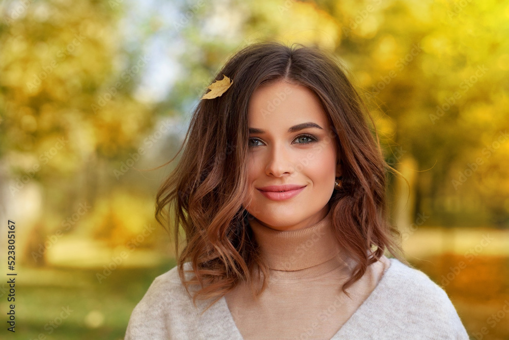 Portrait of beautiful autumn brunette woman with long wavy bob hairstyle smiling. Cute lady on a golden autumn background. Portrait of beautiful autumn brunette woman with long wavy bob hairstyle smiling. Cute lady on a golden autumn background.