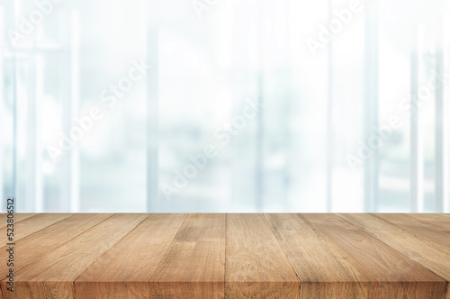 Selective focus.Top of wood  table with window glass and cityscape background