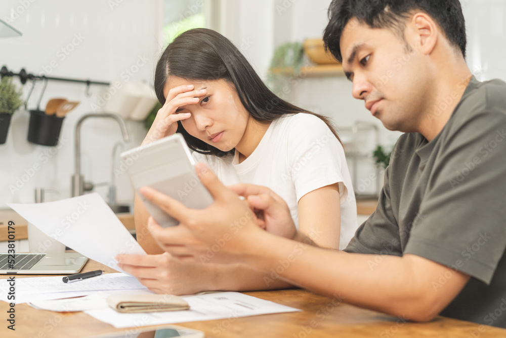 Stressed asian young couple family, wife and husband confused by calculate expense from invoice or bill, have no money to pay. Mortgage, loan causing debt, bankruptcy. Debt problems, Financial people. Stressed asian young couple family, wife and husband confused by calculate expense from invoice or bill, have no money to pay. Mortgage, loan causing debt, bankruptcy. Debt problems, Financial people.