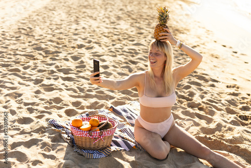 Cheerful young woman enjoy at tropical sand beach. Girl taking selfie photo photo