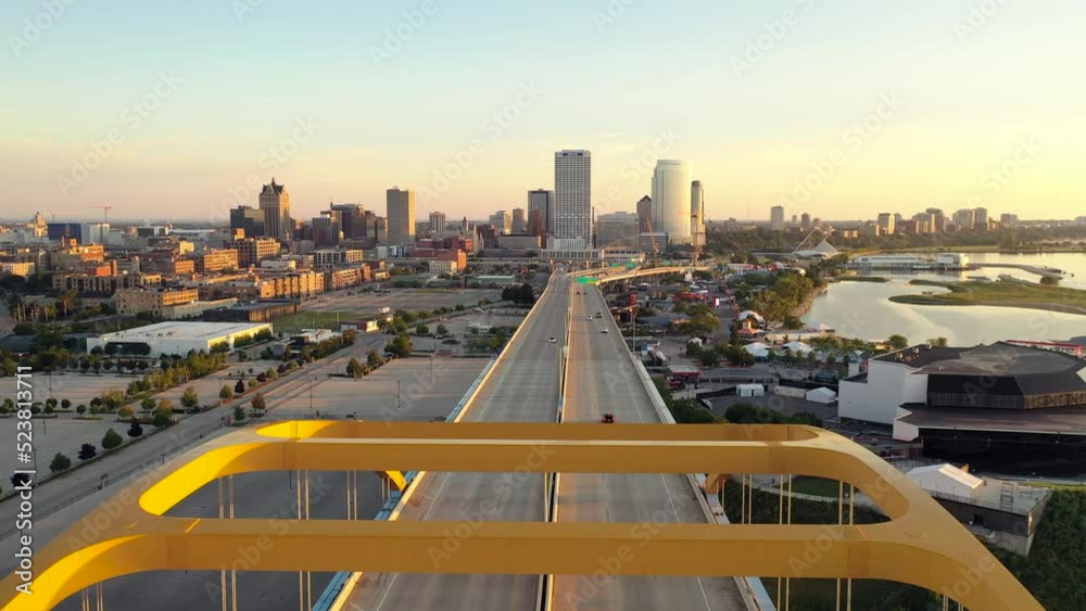 Aerial view of Downtown Milwaukee, Wisconsin, USA. Flying over Hoan Memorial Bridge and highway in morning at sunrise, city skyline in the background. 