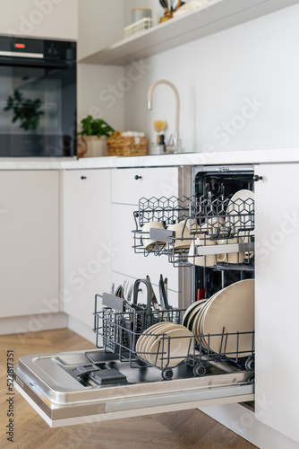 Open dishwasher with clean dishes in kitchen interior design