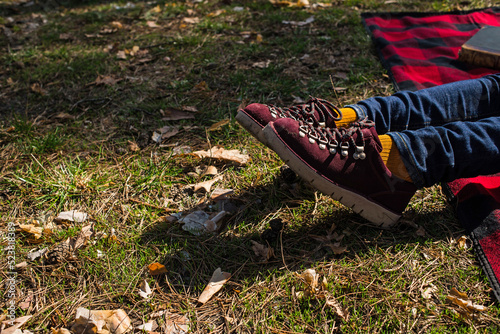 Obraz na płótnie Resting on the grass. Stylish suede shoes on women’s legs. Burgundy shoes and yellow socks. Beautiful shoes on women’s legs. beautiful weekend w salonie
