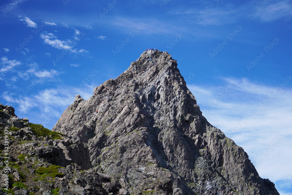晴れた日に日本北アルプス槍ヶ岳に登るたくさんの登山客